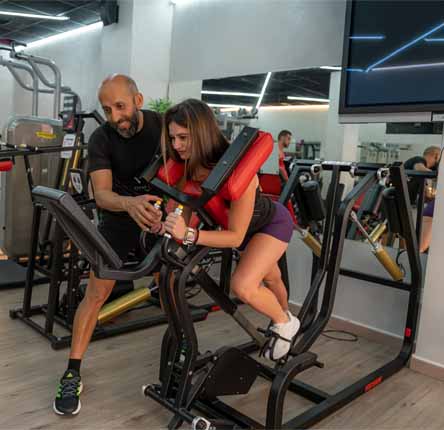 mujer entrena maquina fitness entrenador personal